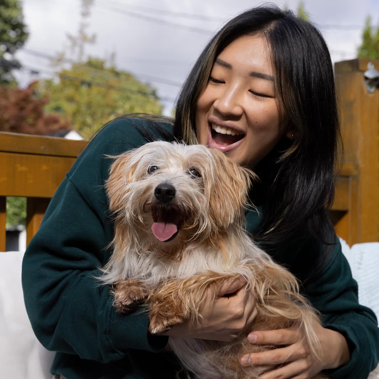 Uma senhora com um cão pequeno nos seus braços