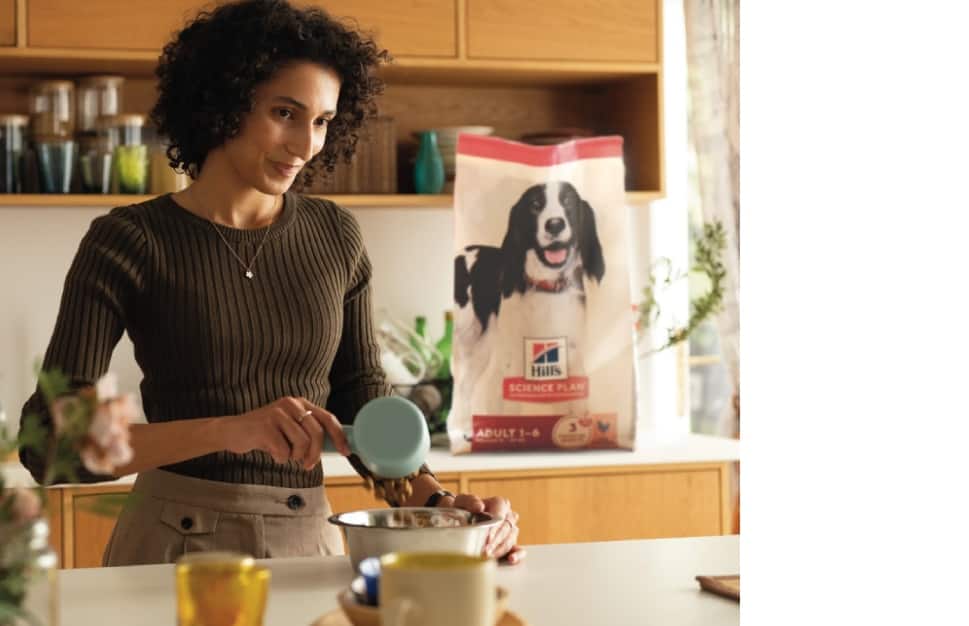 Mulher a servir alimento Hill's num comedouro
